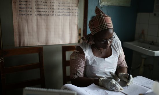 Health worker writing at clinic in Sierra Leone