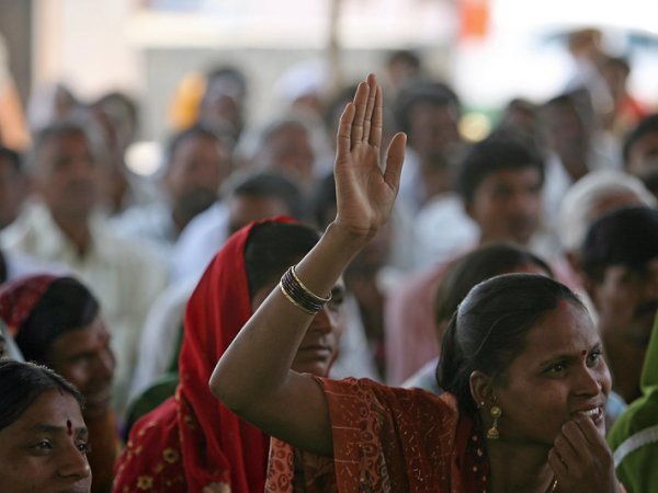 Photo of Indian women, one with her hand raised