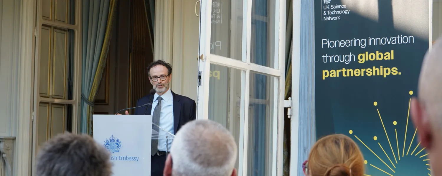 Philippe Guerin speaks from podium to an audience