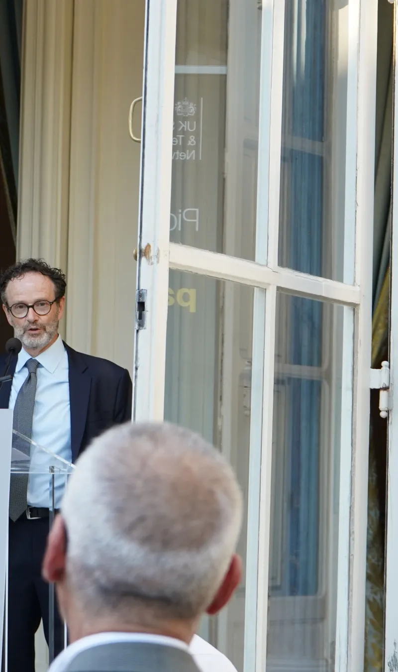 Philippe Guerin speaks from podium to an audience