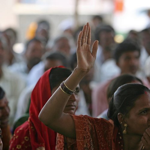 Photo of Indian women, one with her hand raised