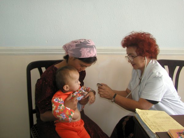 Gp examining a baby